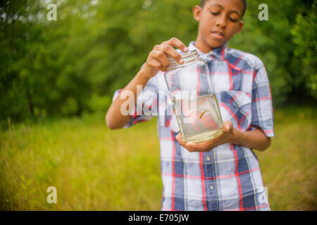 Ragazzo adolescente con pesce in vaso Foto Stock