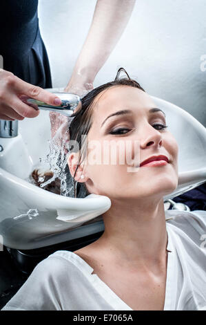 Femmina lavaggio parrucchiere giovane donna capelli nel salone di parrucchiere Foto Stock