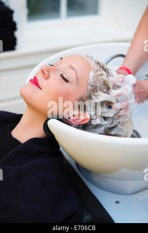 Donna con capelli shampooed in salone Foto Stock