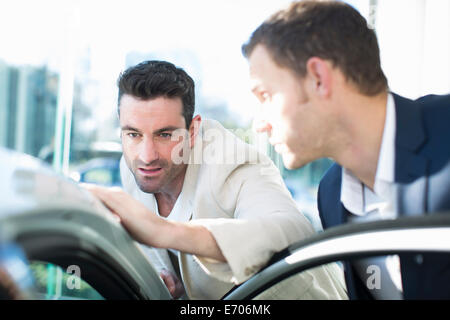 I clienti che cercano a tetto auto in concessionaria auto Foto Stock