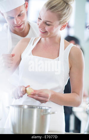 Chef e collega la pelatura di patate in cucina commerciale Foto Stock