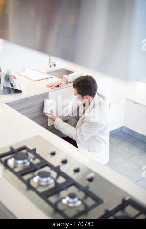 Metà uomo adulto guardando le piastrelle di ceramica in cucina showroom Foto Stock