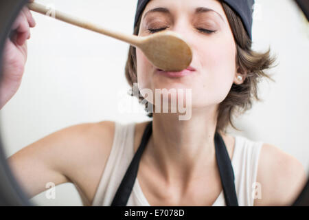 Femmina degustazione chef cibo dalla pentola in cucina commerciale Foto Stock