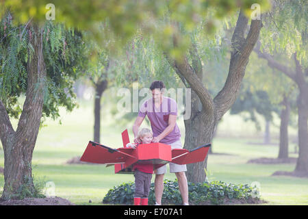 Padre la preparazione di aeroplano giocattolo per suo figlio in posizione di parcheggio Foto Stock