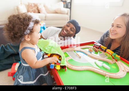 Il padre e la madre a giocare con la mia figlia, treno sul tavolo Foto Stock