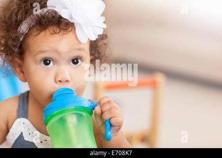 Baby girl bere da sippy cup Foto Stock