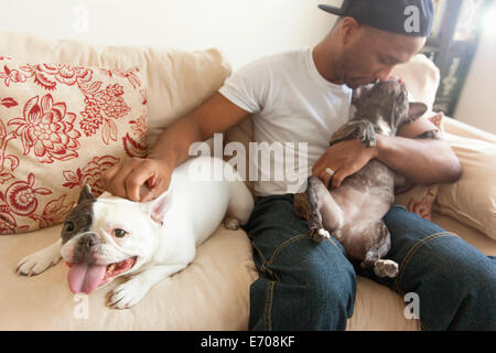 Metà uomo adulto seduto con due Bouledogue francesi Foto Stock