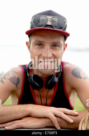 Ritratto di sorridere metà uomo adulto che indossa cappello da baseball a costa Foto Stock