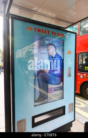 Oxford Street, Londra, Regno Unito. Il 2 settembre 2014. Un video di Gary Lineker gioca su una schermata sul bus stop macchina distributrice per camminatori patatine. Ai visitatori di inviare un tweet per ricevere un codice e una borsa gratuita di patatine. Credito: Matteo Chattle/Alamy Live News Foto Stock