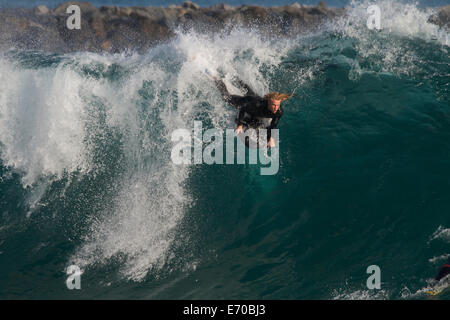 Un bodyboarder prende il largo su un enorme ondata presso la famosa in tutto il mondo navigando in posizione 'cuneo' @ di Newport Beach in California Foto Stock