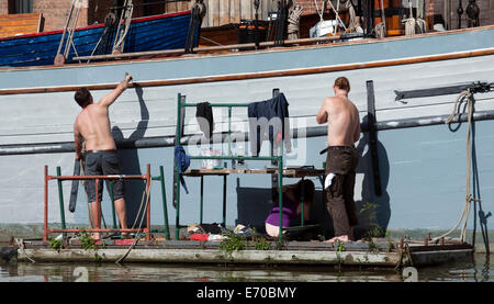 La verniciatura di una vecchia nave a vela in Gloucester Docks, Gloucester. Foto Stock