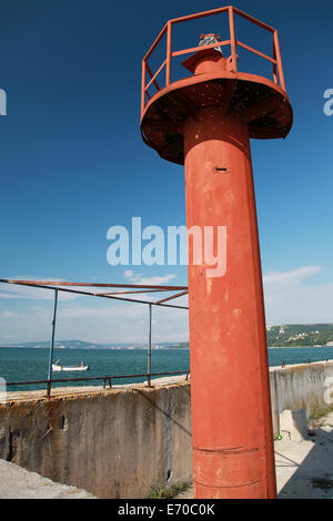 Faro rosso sopra Palo profondo cielo blu Foto Stock