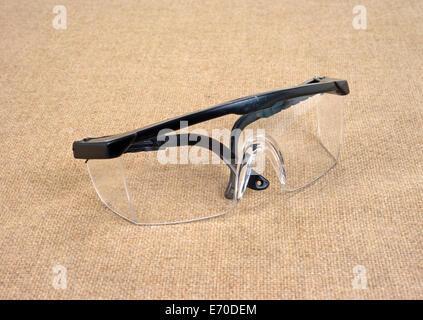 Una coppia di usato occhiali di sicurezza su una tela dello sfondo. Foto Stock