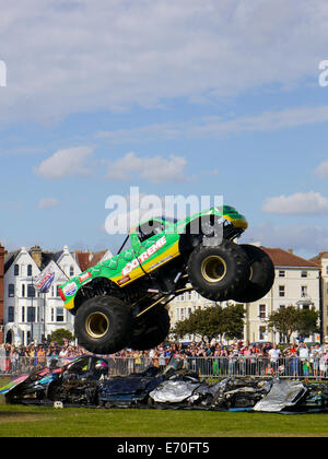 La estrema monster truck salta su vetture frantumato all'estremo stunt show di Portsmouth, Inghilterra Foto Stock