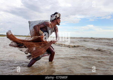 Fisherman heaving a net in shallow waters in the bay of Bengal, Chittagong, Bangladesh Foto Stock