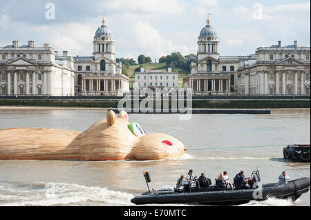 Greenwich, Londra, Regno Unito. Il 2 settembre 2014. Un gigante di Ippona scultura HippopoThames denominata, è trainato fino al fiume Tamigi all'bemusement di spettatori. Il 21 metri lungo la scultura è il lavoro dell'artista olandese, Florentijn Hofman. Nella foto: Florentijn Hofman con la creazione di "HippopoThames" è trainato fino al Tamigi passato la Old Royal Naval College di Greenwich. Credito: Lee Thomas/Alamy Live News Foto Stock