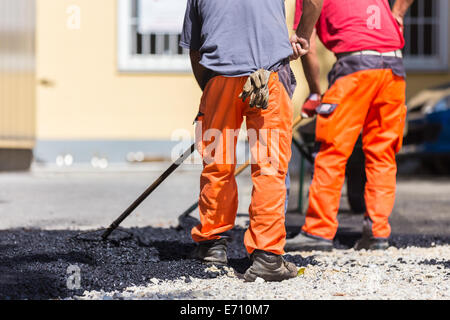 Rivestimento in asfalto il lavoro manuale. Foto Stock