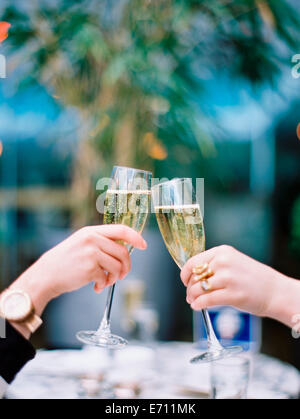 Due donne tostare ogni altra con bicchieri di champagne. Foto Stock