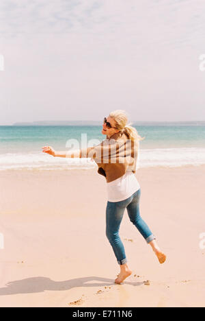 Una donna di ballare a piedi nudi sulla sabbia, che si esprime attraverso i movimenti. Foto Stock