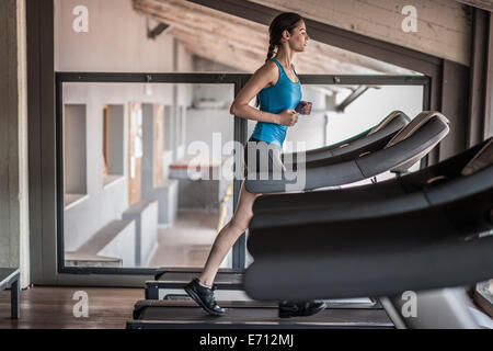 Giovane donna in corsa su tapis roulant Foto Stock