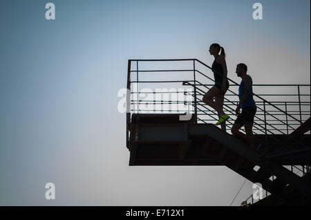 L uomo e la donna salire le scale, silhouette Foto Stock