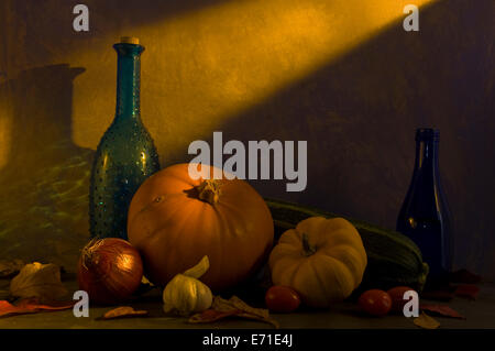 Still Life di bottiglie e verdure bagnato in un giallo e arancione glow dall'autunno (caduta) sun Foto Stock