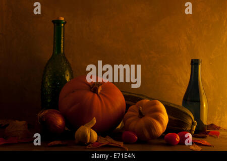 Still Life di bottiglie e verdure bagnato in un giallo e arancione glow dall'autunno (caduta) sun Foto Stock