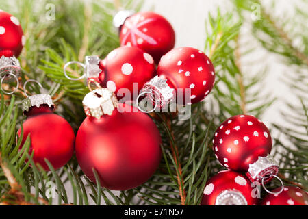 Rosso di Natale a tema sfondo con una grande pallina su di una piazza di rustico hessian circondato da decorativi sfere di piccole dimensioni con polk Foto Stock