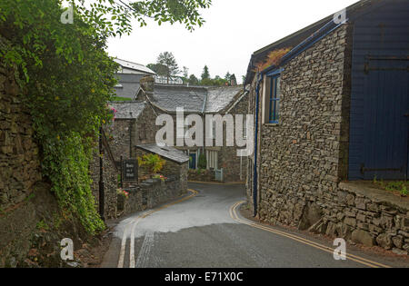 Strada stretta tra avvolgimento storici edifici in pietra in inglese antico villaggio nei pressi di Windemere, Lake District, Cumbria, Inghilterra Foto Stock