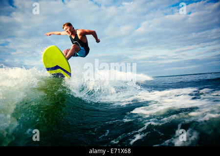 Surfista maschio cavalcando le onde del mare Foto Stock