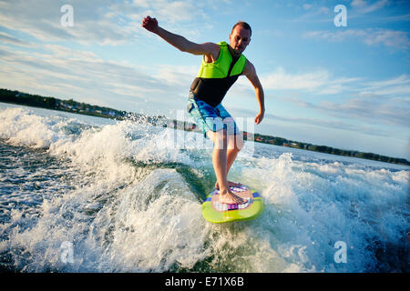 Giovane uomo surfboarding in mare Foto Stock