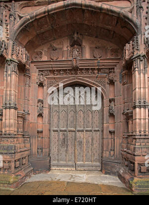 Spettacolare arcuata porta in legno con intricati intarsi circondato da intricate sculture in pietra rossa in ingresso alla storica cattedrale di Chester Inghilterra Foto Stock