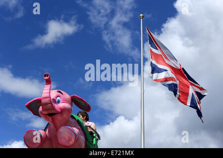 Pink Elephant è visto volare in aria a una fiera con una Unione Jack dietro. Dodgems sono visibili anche con una Unione Jack dietro Foto Stock