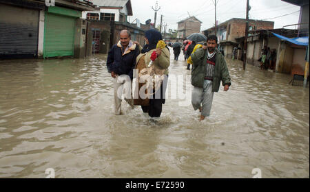 Srinagar Kashmir. 4 Sep, 2014. Lasciare i residenti attraverso acque alluvionali con altri in Srinagar, le autorità dicono le forti piogge hanno provocato inondazioni e smottamenti nella parte indiana del Kashmir, uccidendo almeno 14 e molte case danneggiate in la peggiore inondazione in 22 anni. Credito: sofi suhail/Alamy Live News Foto Stock