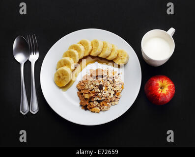 A base di cereali con banana e rabboccato con miele, latte e Apple per la salute Foto Stock