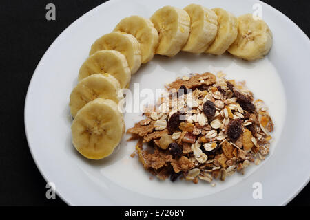 Cereali mescolati al latte con banana e rabboccato con il miele per la salute Foto Stock