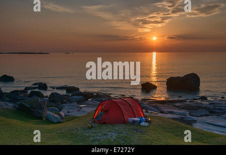 Godendo il sole di mezzanotte sulla bellissima spiaggia di Uttakleiv nelle Isole Lofoten in Norvegia Foto Stock