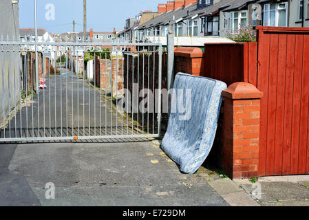 Materasso oggetto di pratiche di dumping sul retro di una fila di case a schiera in Blackpool Lancashire Foto Stock