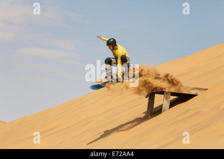 Sand Boarding sulle dune del deserto del Namib, nei pressi di Swakopmund, Namibia Foto Stock