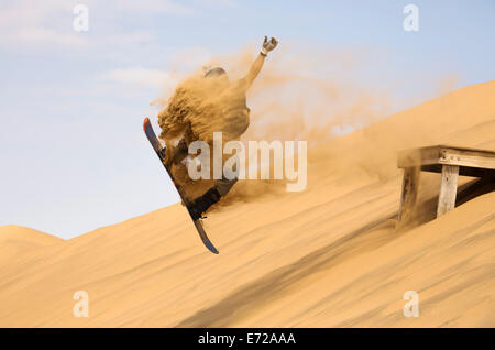 Sand Boarding sulle dune del deserto del Namib, nei pressi di Swakopmund, Namibia Foto Stock