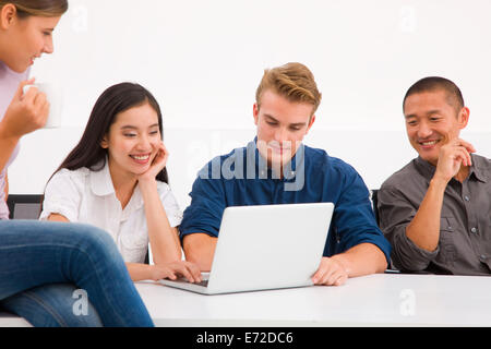 Multi etnico gruppo di dirigenti cercando laptop Foto Stock