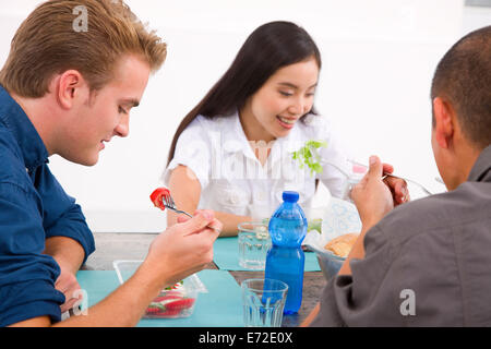 Diversi gruppi di amici a mangiare cibo Foto Stock