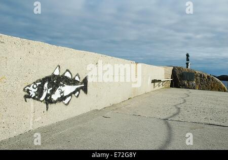 Solo il merluzzo bianco (Gadus morhua) graffiti in Kijeoya, Svolvaer, Lofoten, Norvegia con statua sullo sfondo Foto Stock