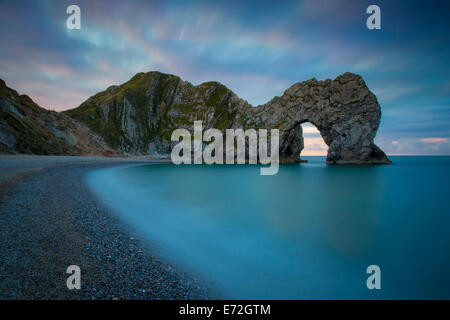 Cielo colorato all'alba su Durdle porta lungo la Jurassic Coast, Dorset, Inghilterra Foto Stock