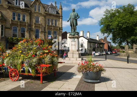 Display floreali e statua di Sir Robert Peel, luogo di mercato, Bury, Greater Manchester, Inghilterra, Regno Unito Foto Stock