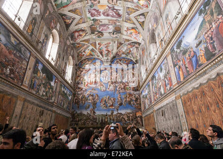 Turistica prendendo immagini per la creazione di Adamo di Michelangelo soffitto della Cappella Sistina. Foto Stock