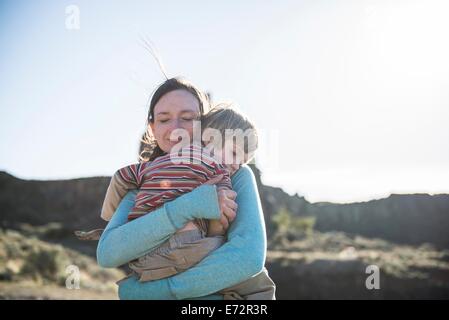 Una madre tiene il suo giovane figlio a confortarlo dopo essere caduta giù camminando sui sentieri di Frenchmans Coulee nella parte orientale Foto Stock