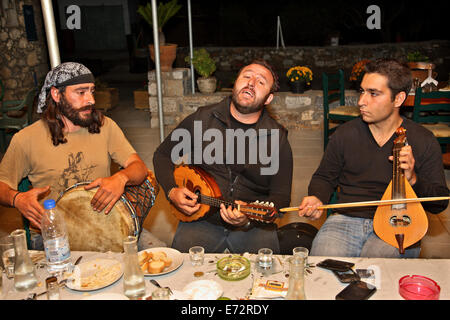 I musicisti in un 'Rakokazano' ('Raki distillazione ") nel villaggio di Fourni, Epano Mirabello, Lassithi, Creta, Grecia. Foto Stock