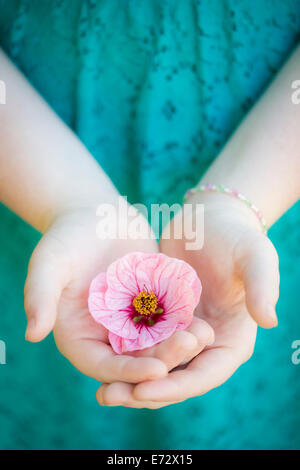 Ragazza adolescente (13-15) con fiore in mano Foto Stock