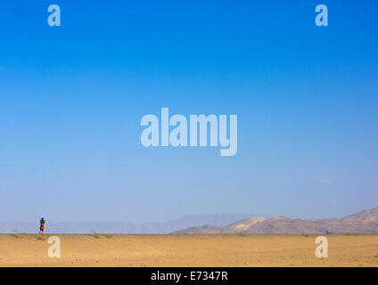 Etnia Afar uomo a camminare da sola nel deserto, Assayta, Etiopia Foto Stock